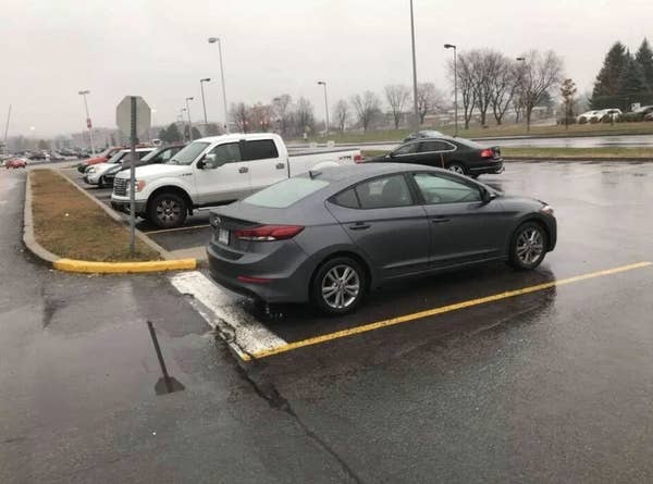 a person parked in a lane next to a parking spot