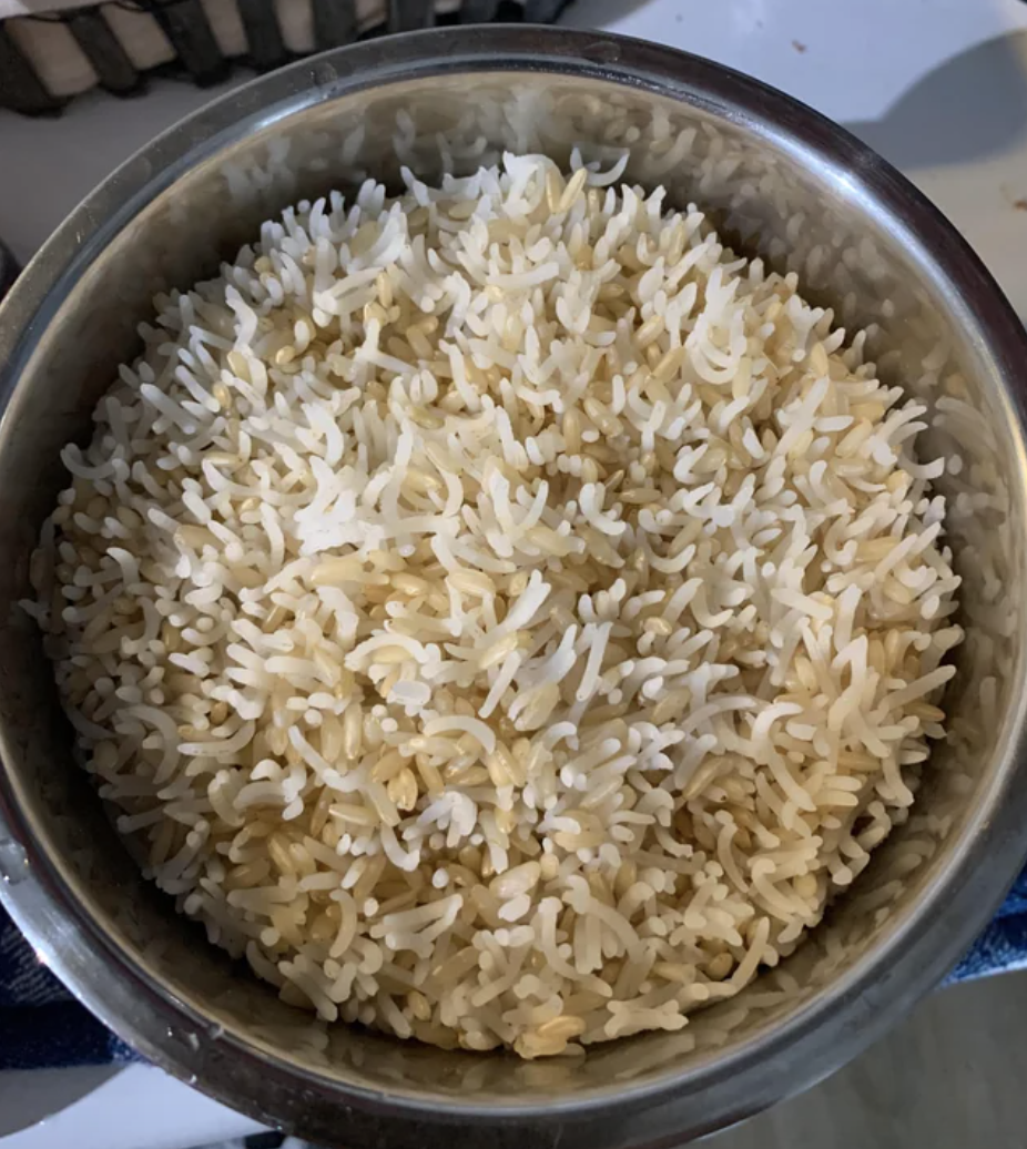 Brown and white rice cooking vertically in a pan, almost like thick porcupine quills