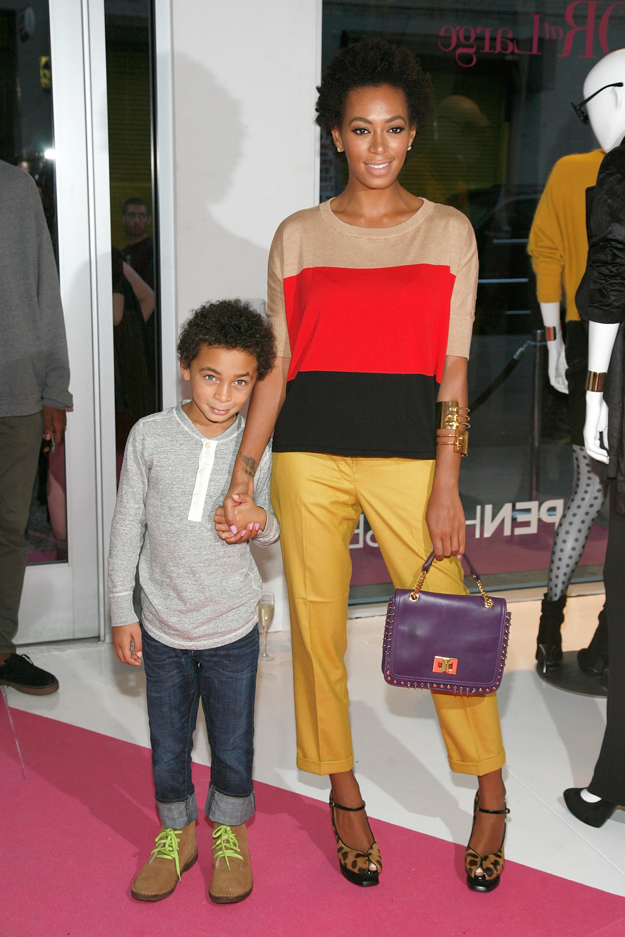 Closeup of Julez and Solange holding hands at an event when he was a toddler