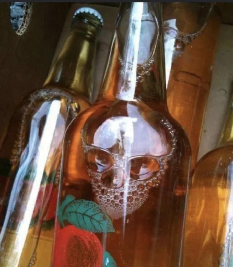 A bottle containing a liquid with bubbles in the shape of a skull