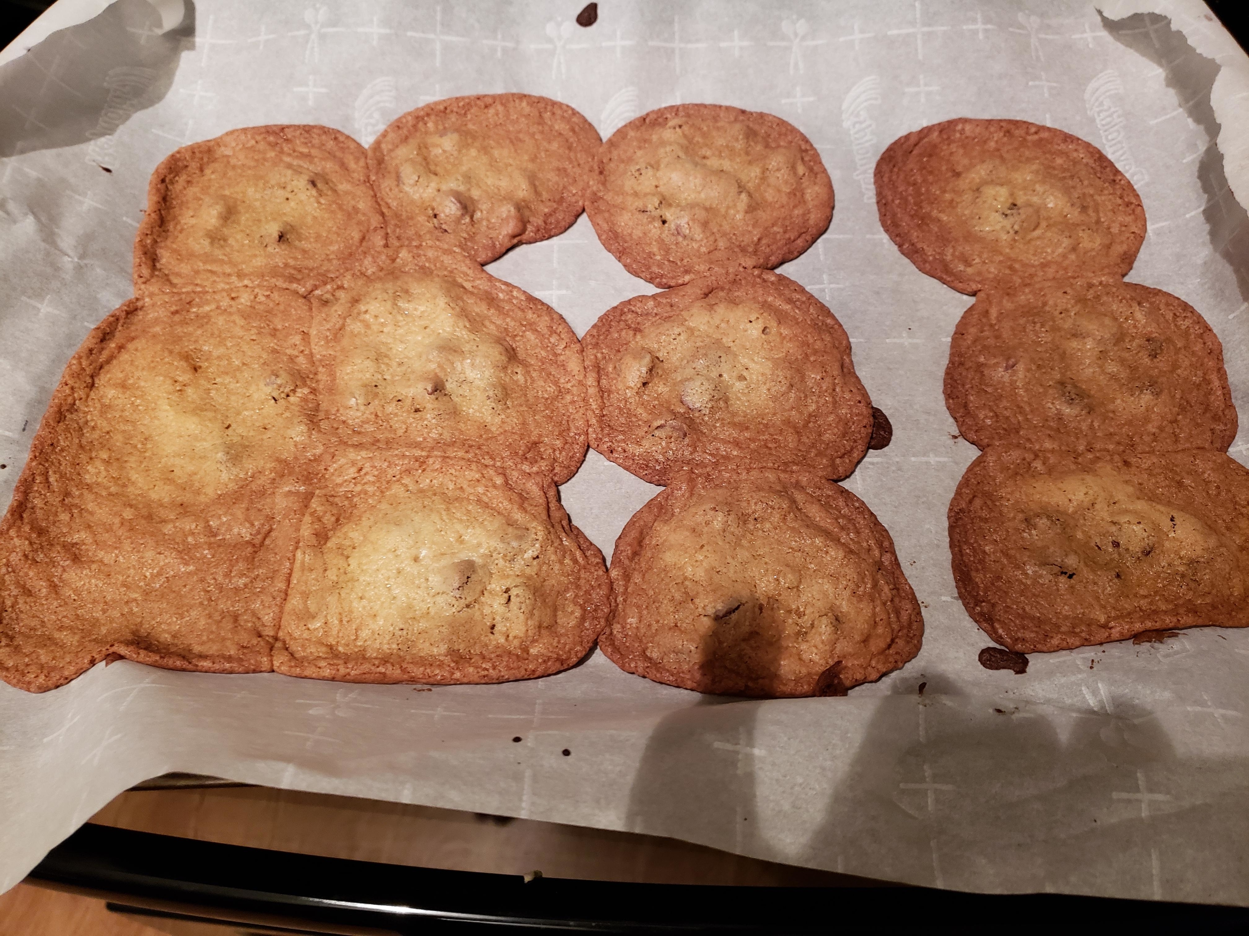 flat chocolate chip cookies on a sheet tray
