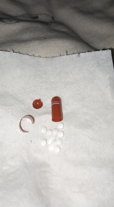 capsule has been broken to reveal a bunch of pills