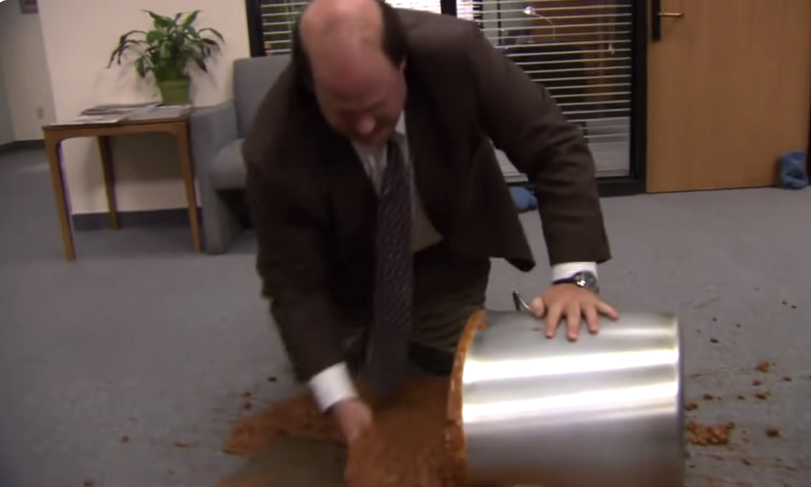 kevin from the office scooping up chili from the floor