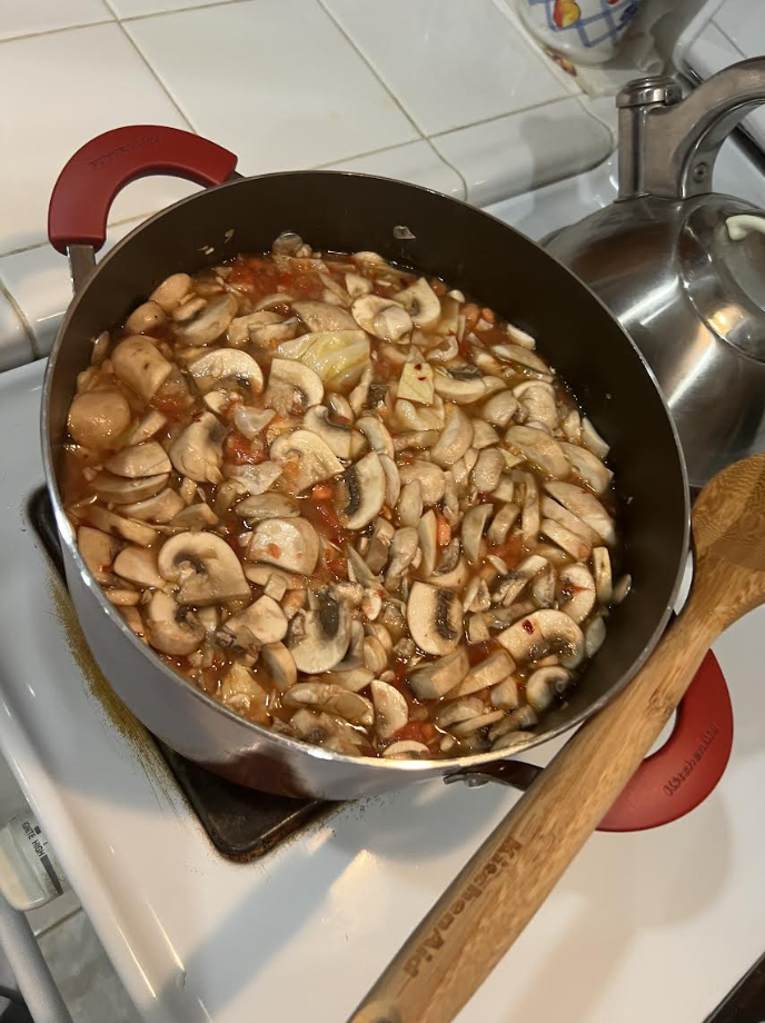 Pot of cabbage soup with mushrooms cooking on the stove