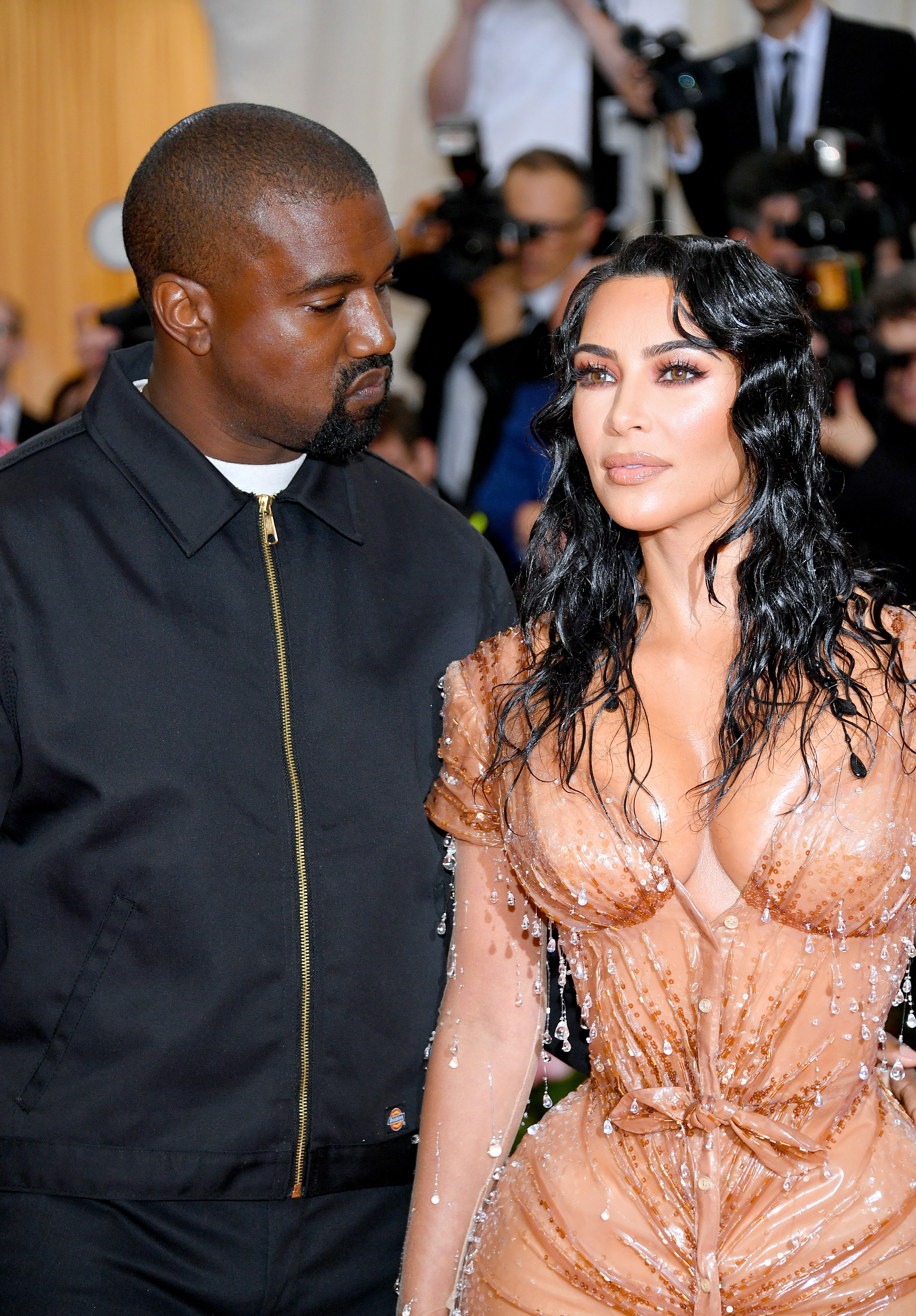 Close-up of Ye and Kim with paparazzi behind them