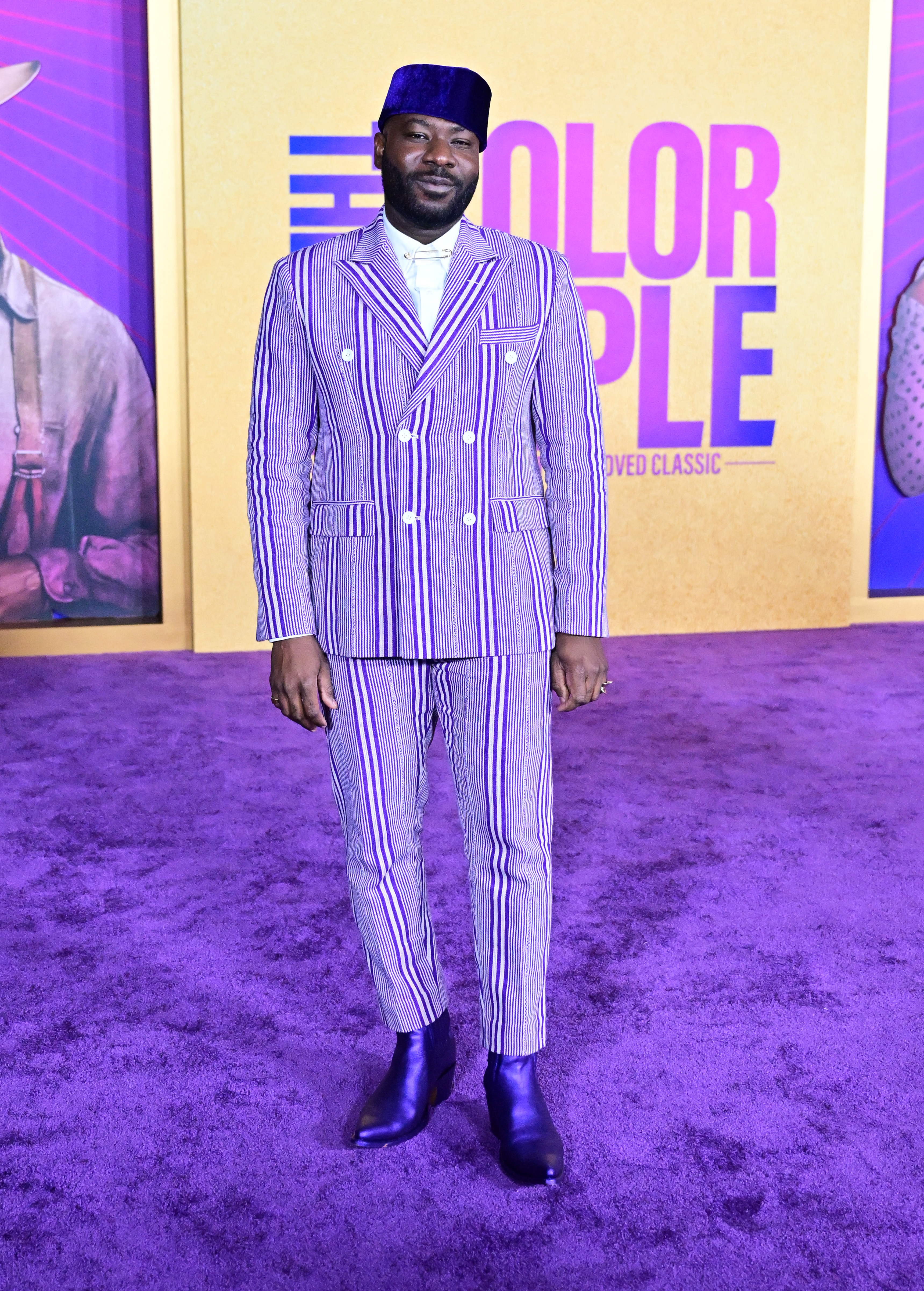 Blitz in a purple and white striped suit and purplish blue kufi hat