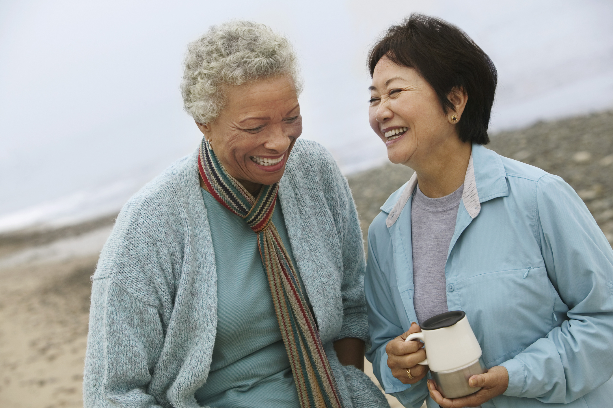 two older women laughing at the beach