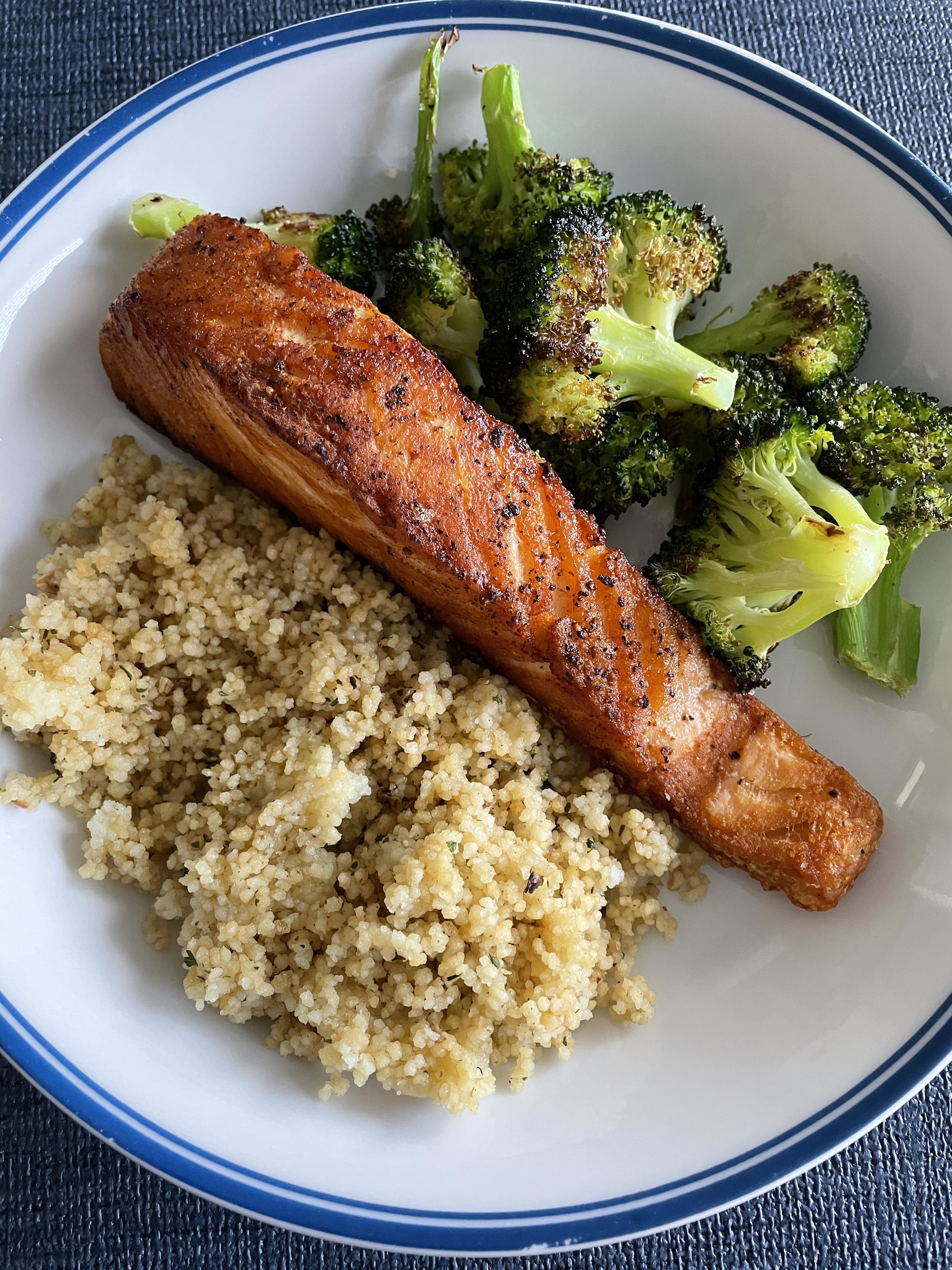 roasted salmon on a plate with couscous and broccoli