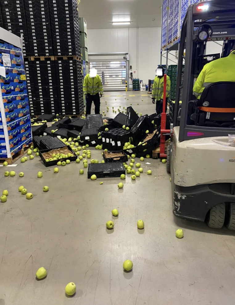 A bunch of spilled apples in a warehouse