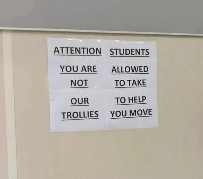 A sign that says &quot;attention students you are not allowed to take our trollies to help you move&quot; but the way it&#x27;s printed reads &quot;attention you are not our trollies&quot;