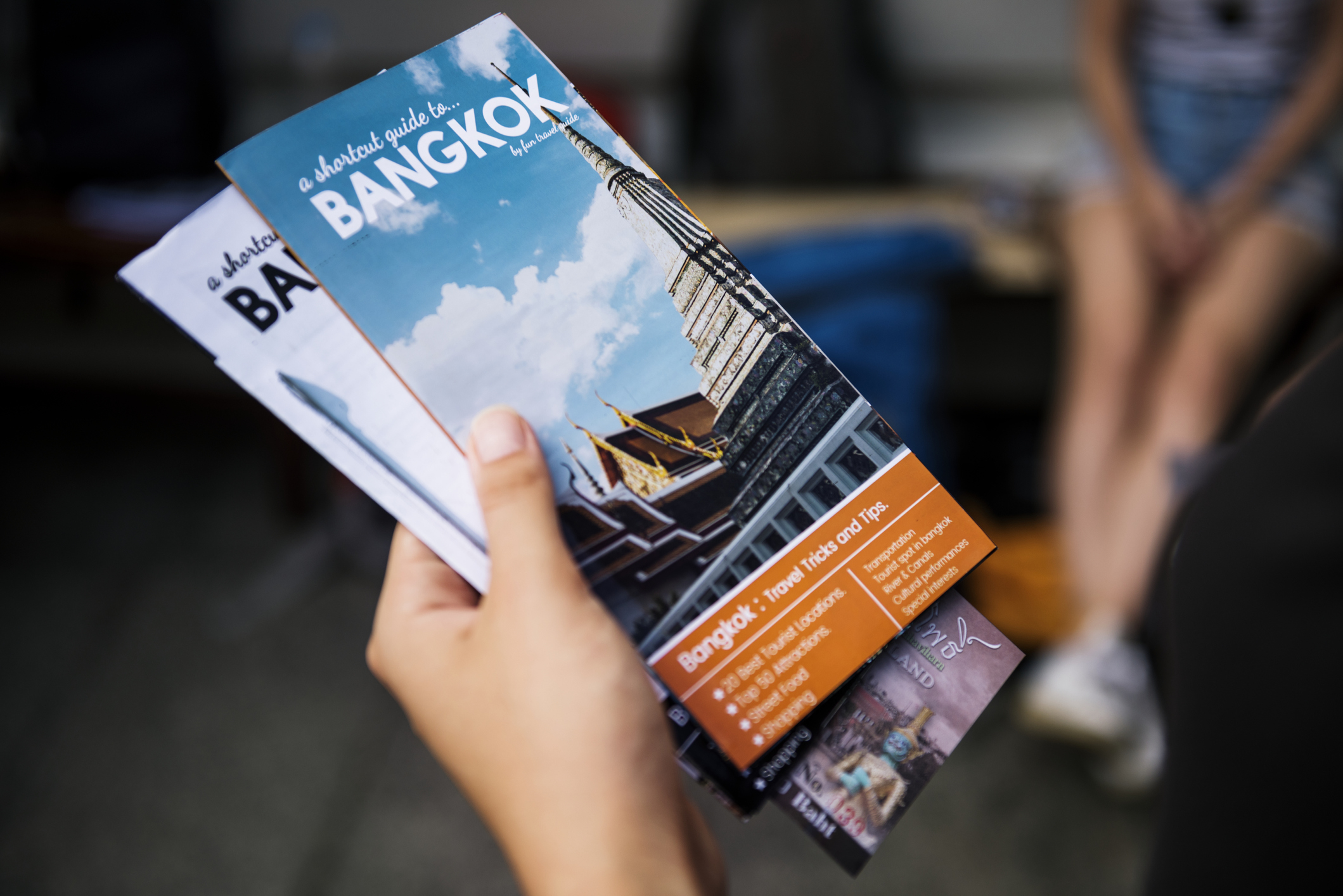 A hand holding travel brochures