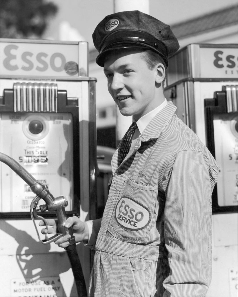 A gas station attendant holding a pump