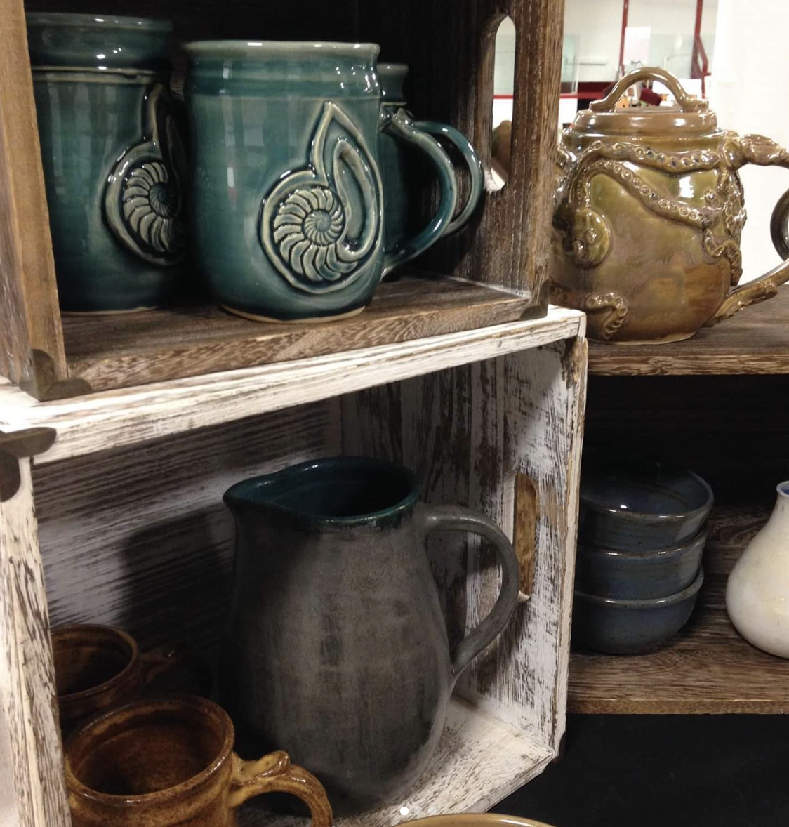 A collection of well-made pottery mugs and vases and bowls.