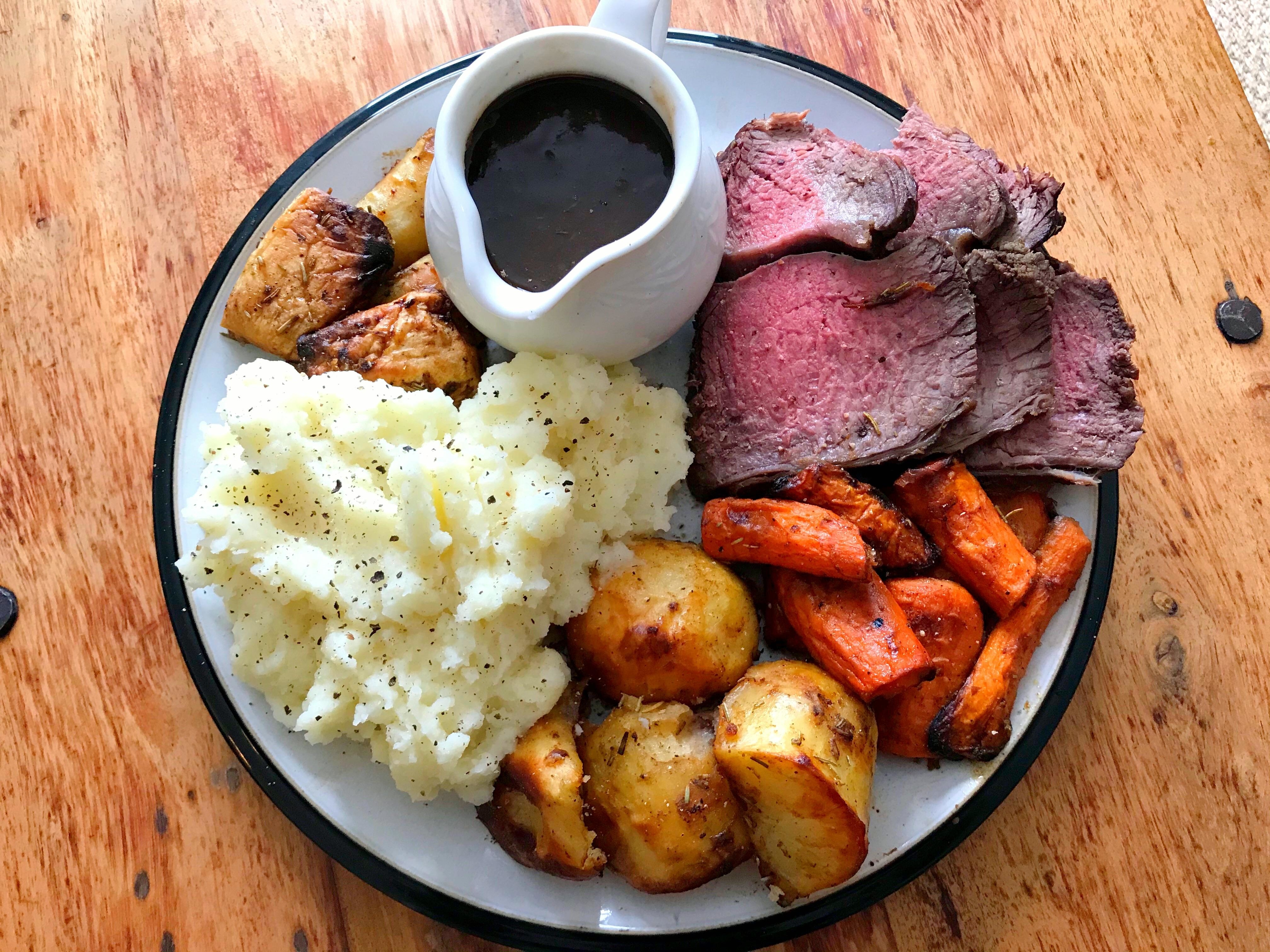 a plate with roasted meat, vegetables, and mashed potatoes