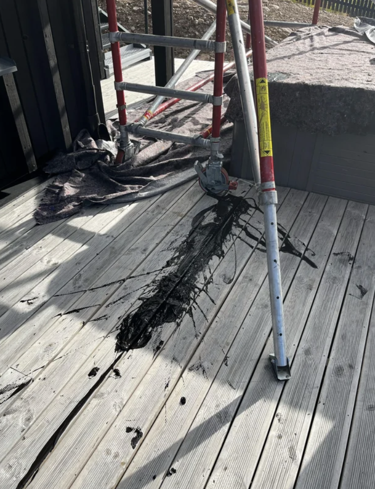 Black paint spilled on a wood porch