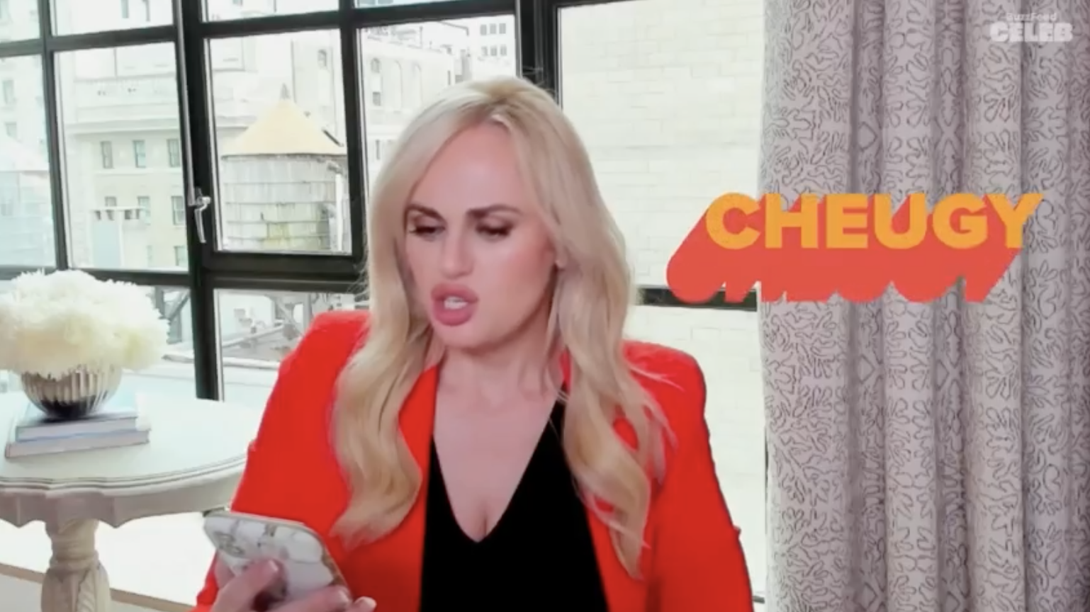 Rebel Wilson looking at her phone with the word &quot;cheugy&quot; next to her