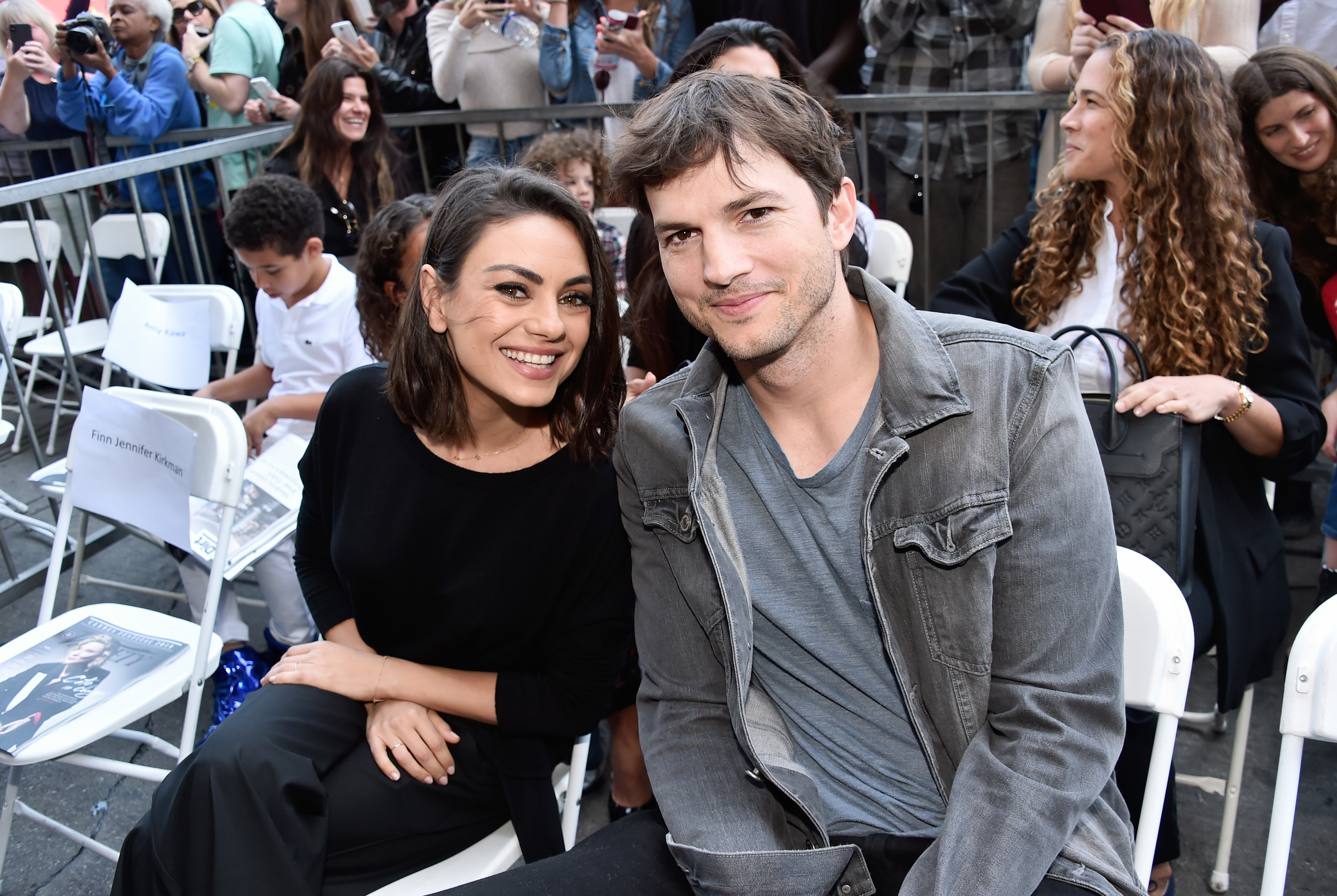 Close-up of Ashton and Mila smiling and sitting together