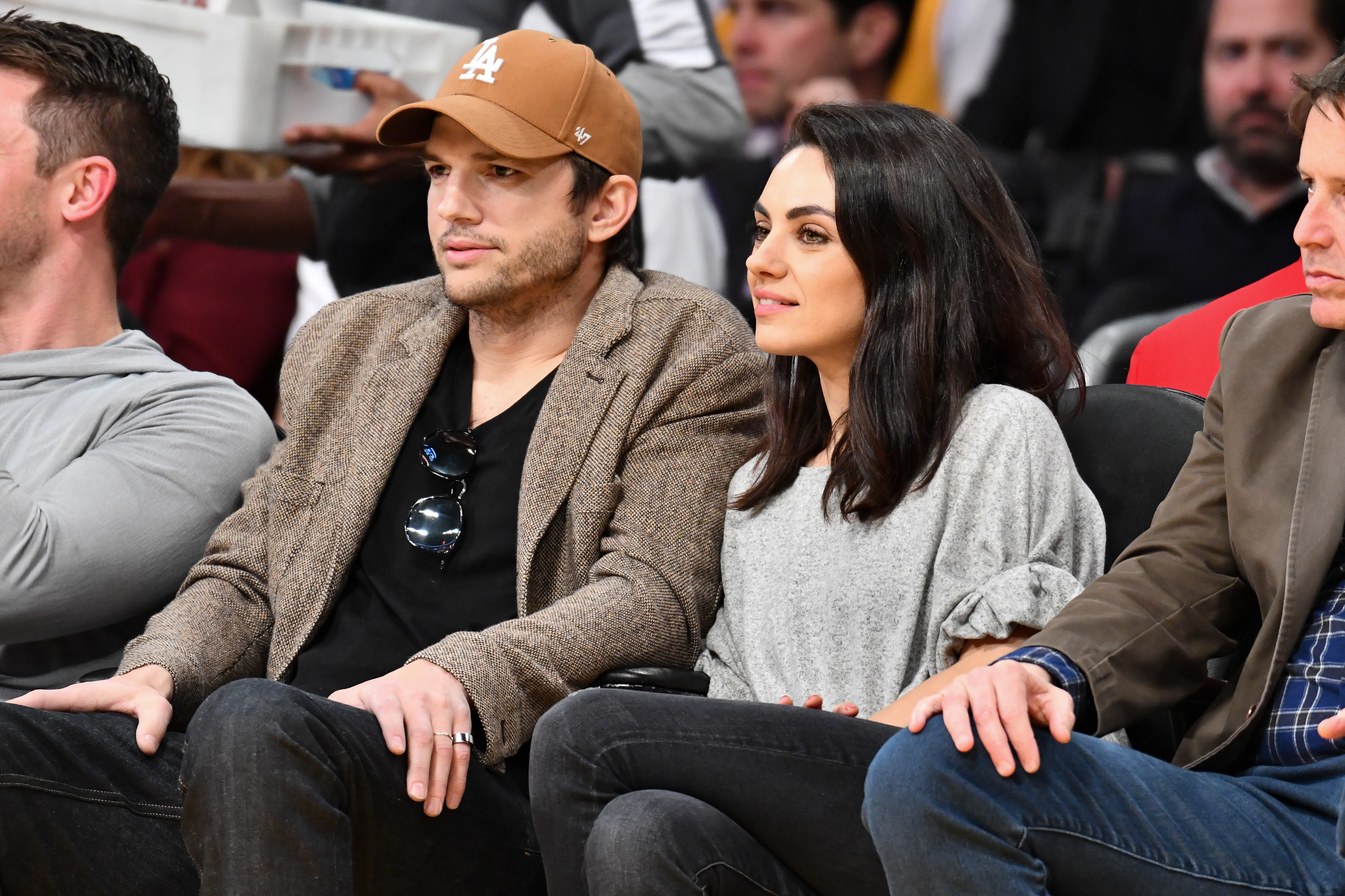Close-up of Ashton and Mila sitting together in an audience