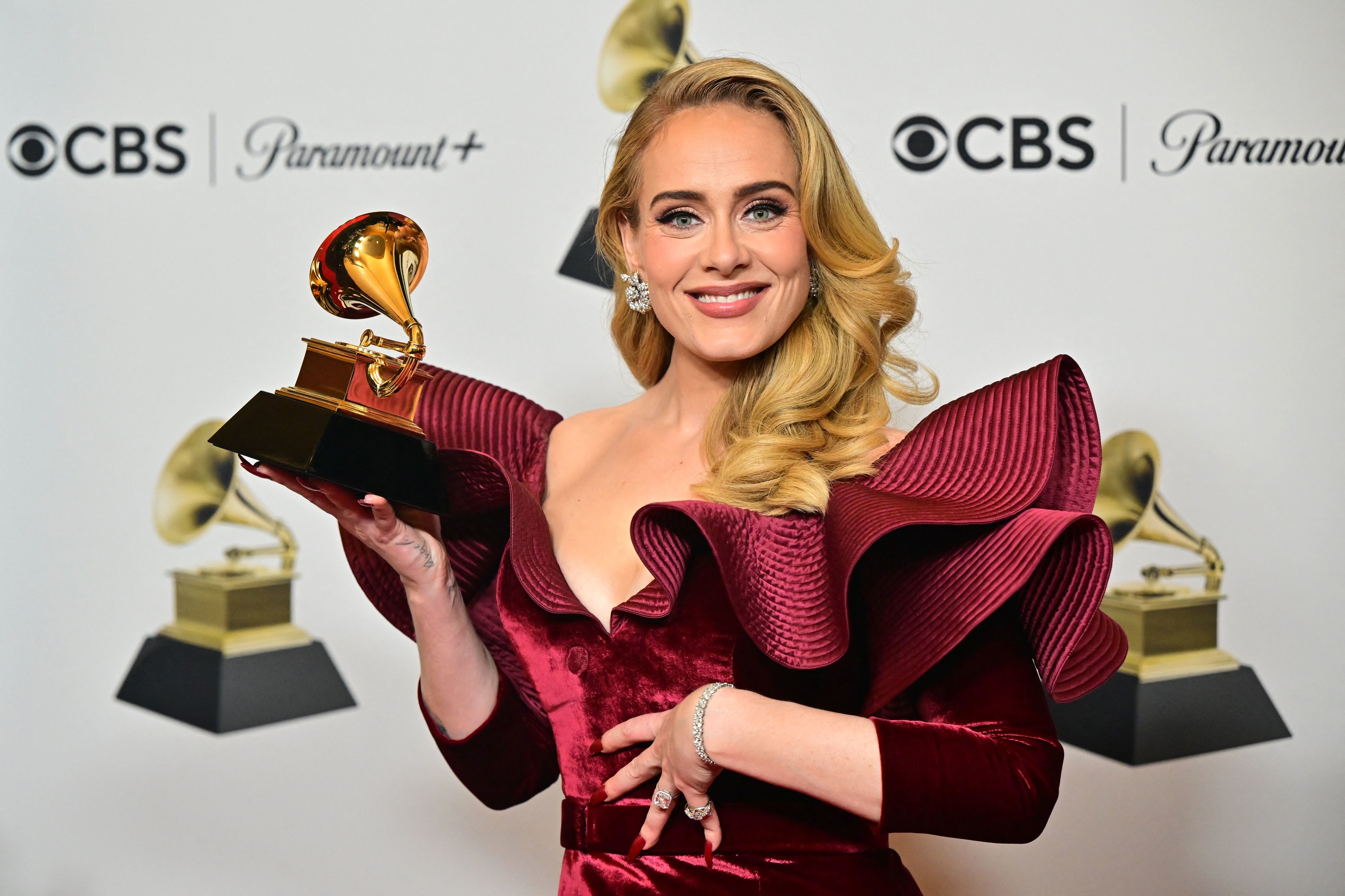 Close-up of Adele holding a Grammy and smiling