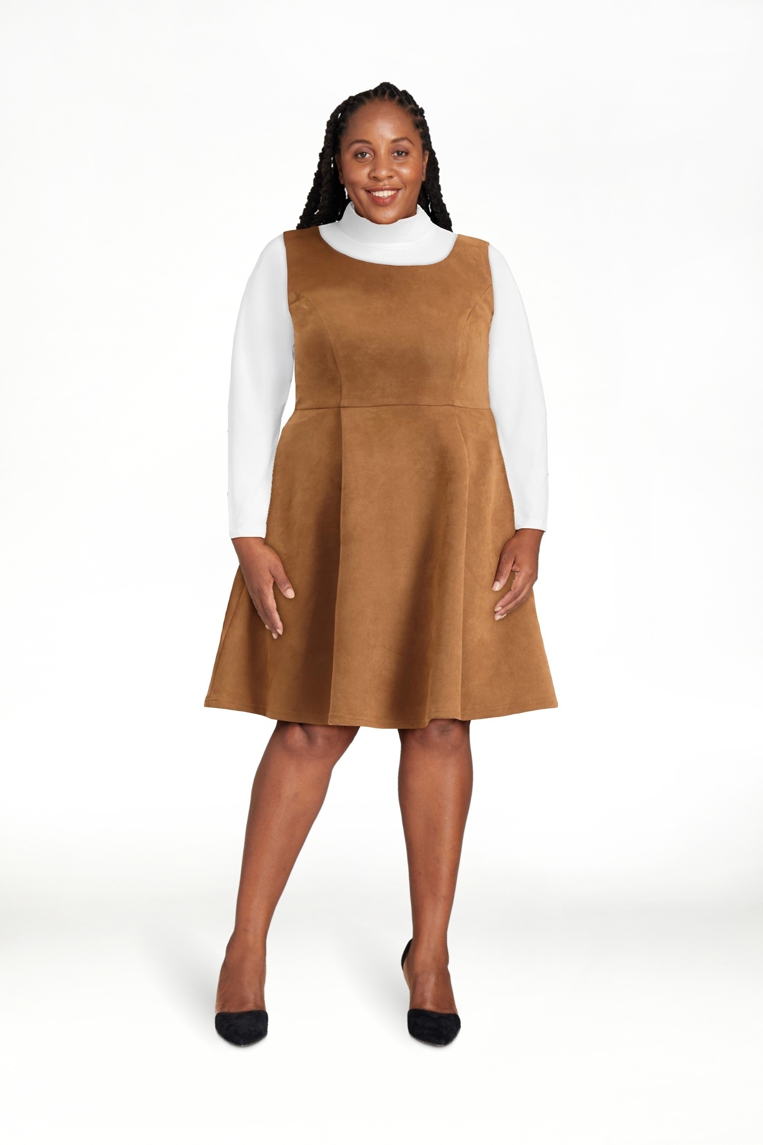model wearing the brown overall dress with a white long sleeve underneath