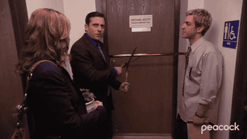 Michael Scott attempting to cut the ribbon of the door for the Michael Scott Paper Company office