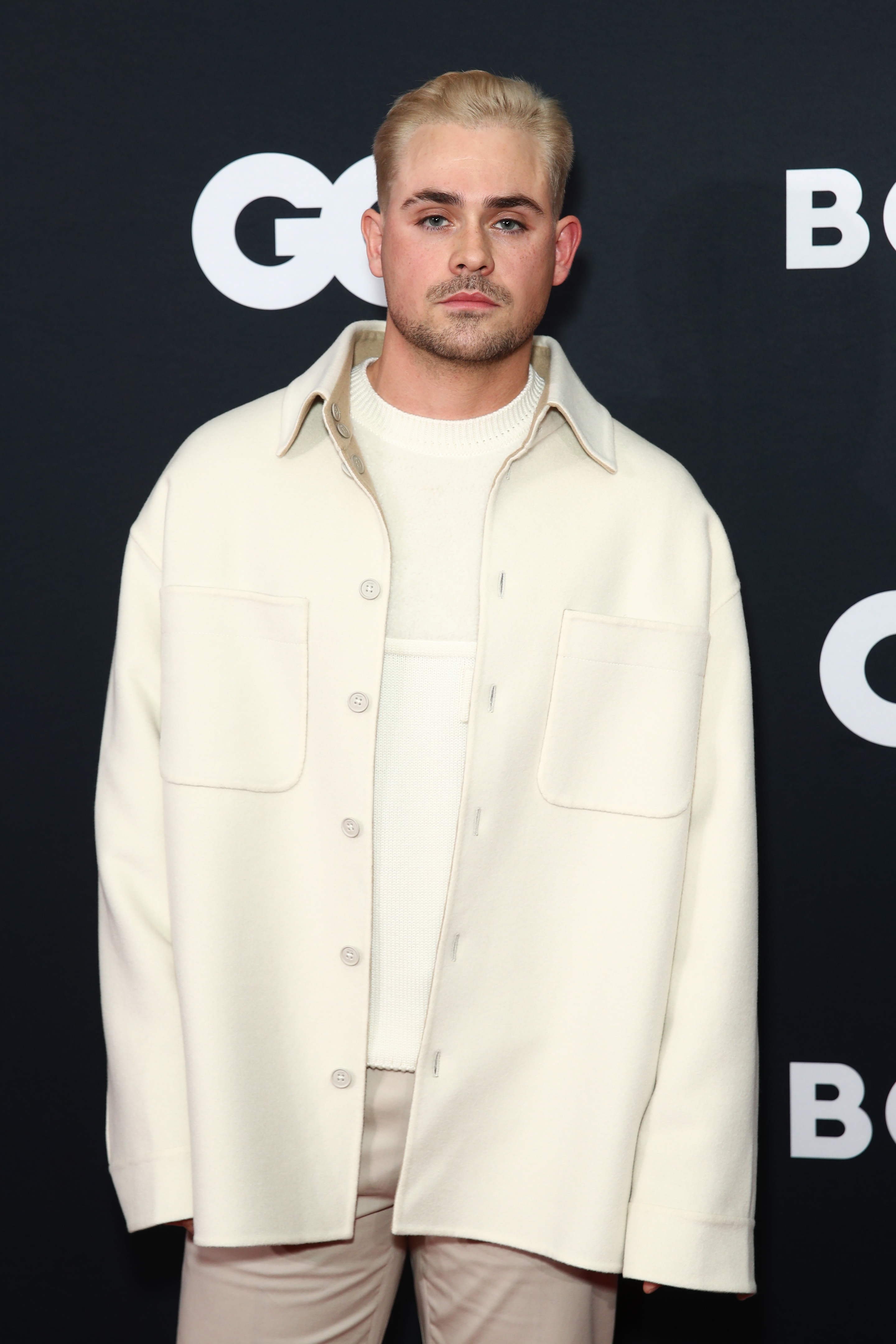 closeup of him wearing an oversized coat at an event