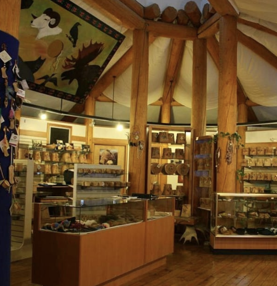 A shop with wooden pillars and full of displays of Native art pieces.