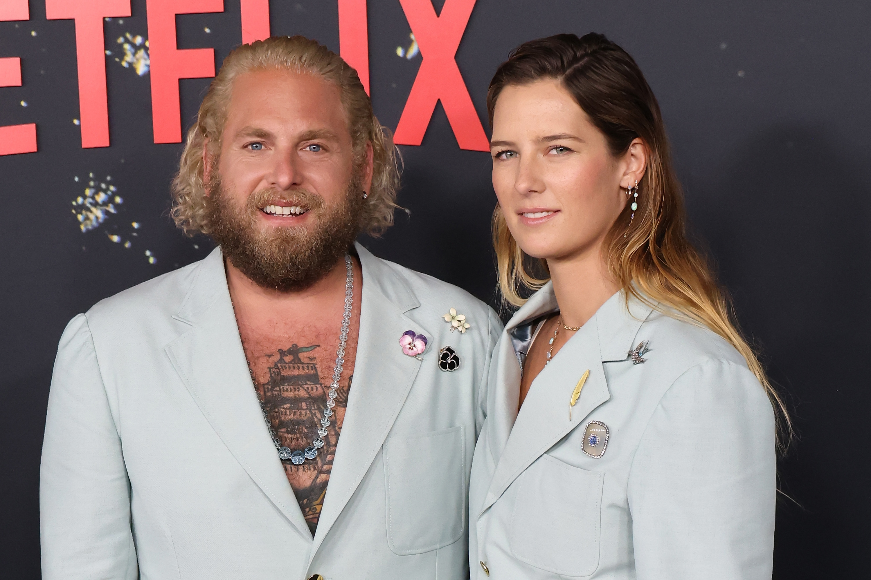 Jonah and Sarah in matching suits at a media event
