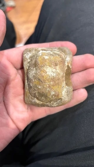 someone holding a rock-like substance that resembles ravioli