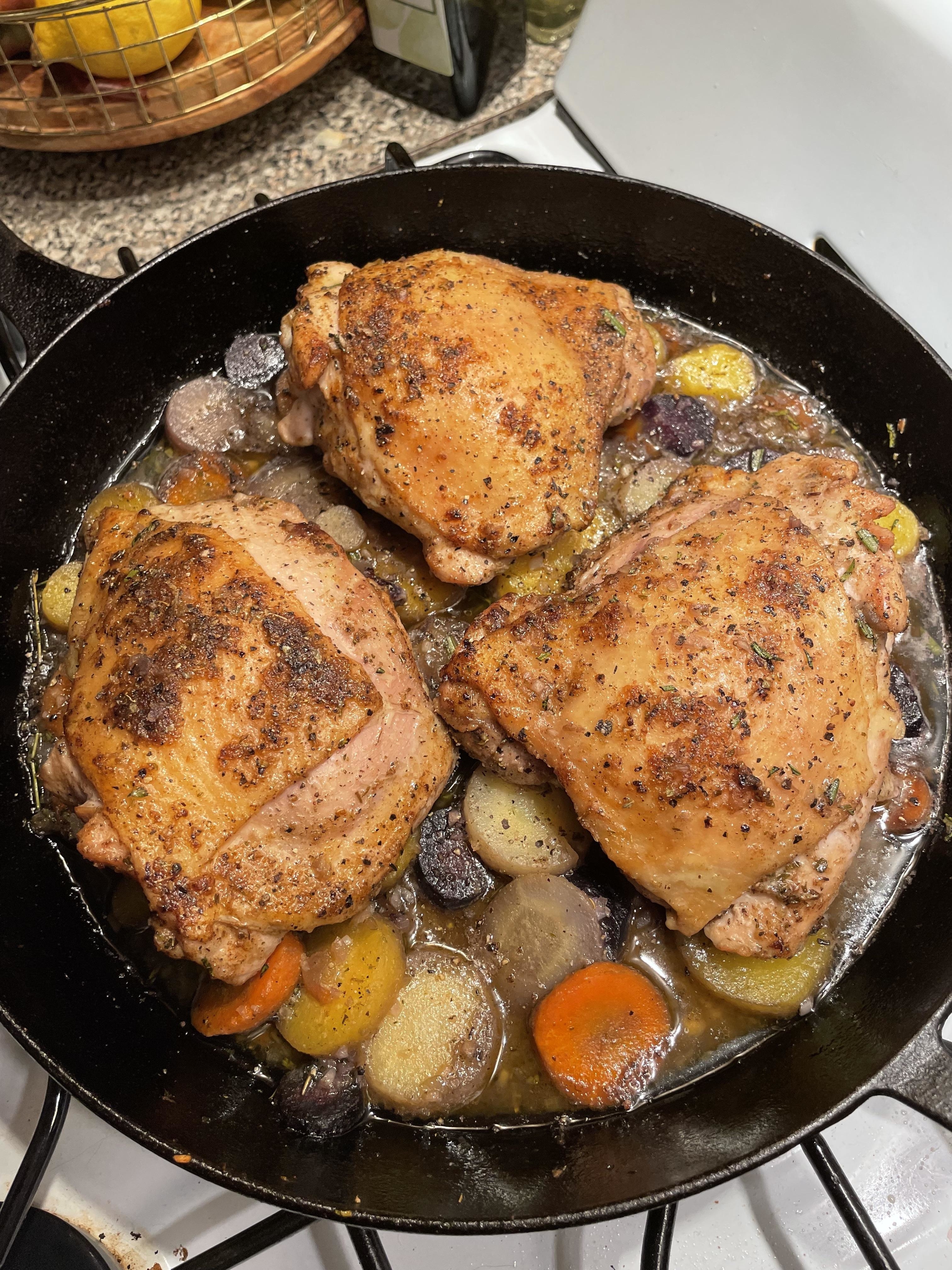 chicken thighs in a cast iron skillet with vegetables
