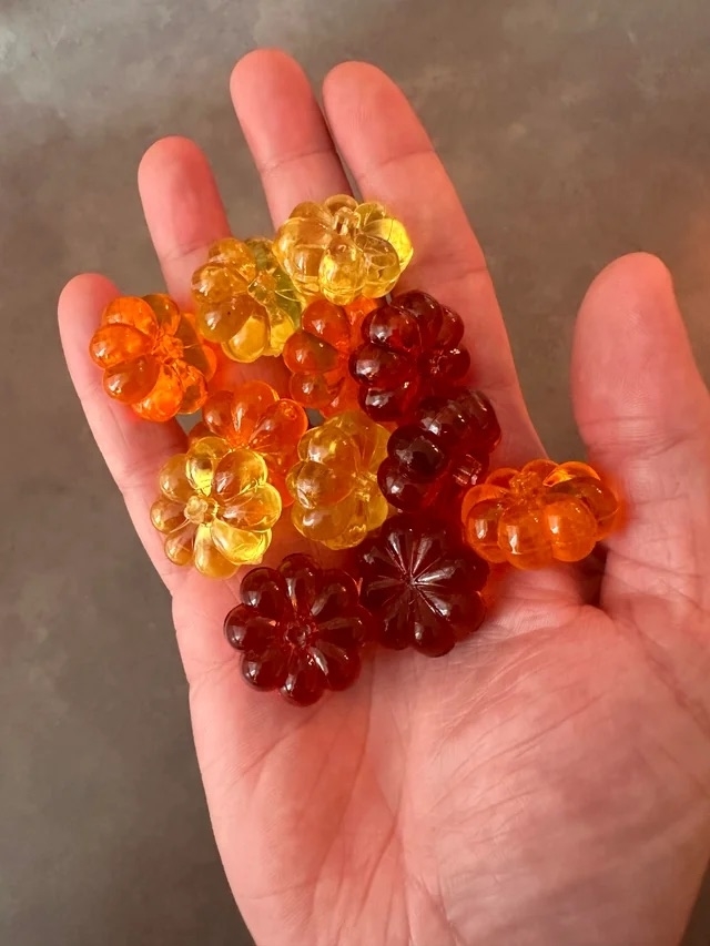 someone holding colorful decorations that look like gummies