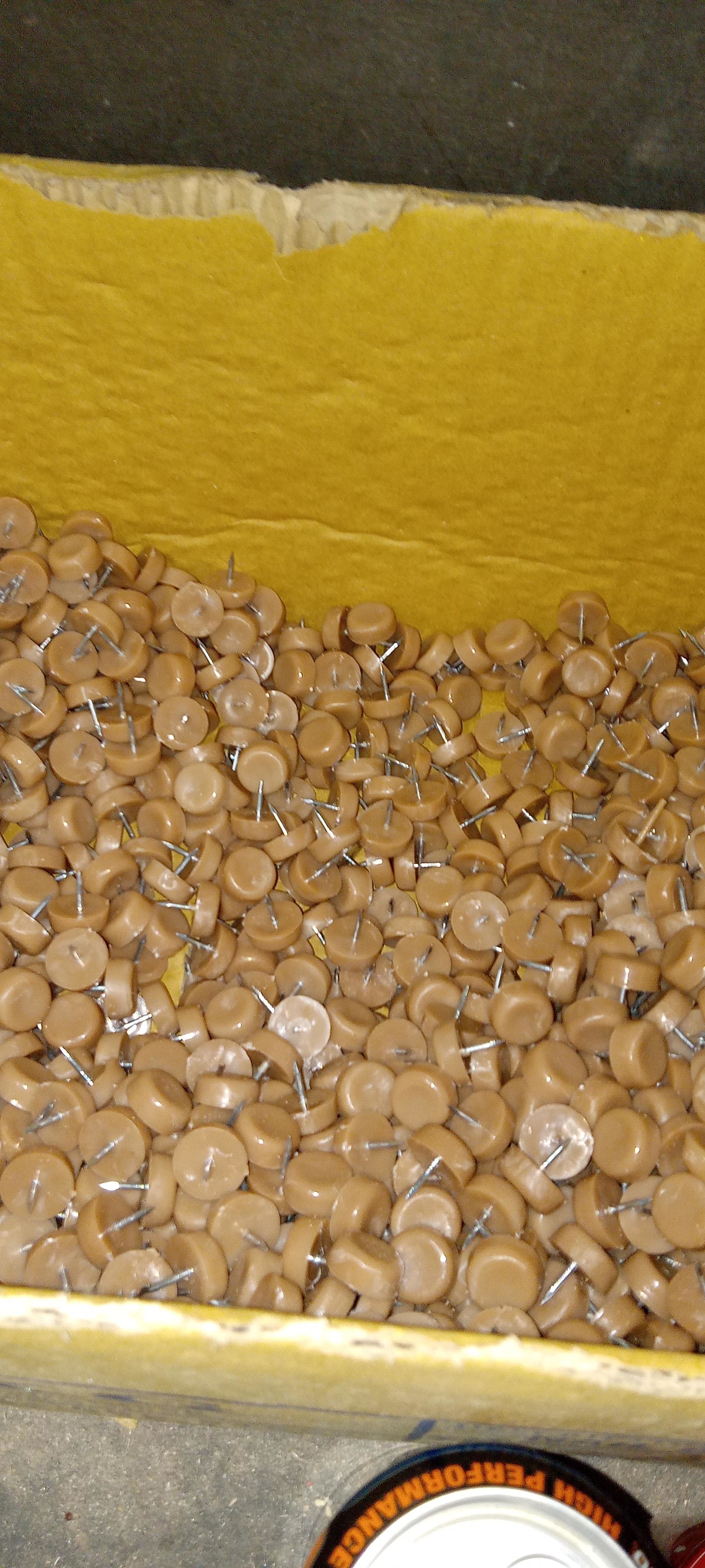 a bin of tan colored tacks