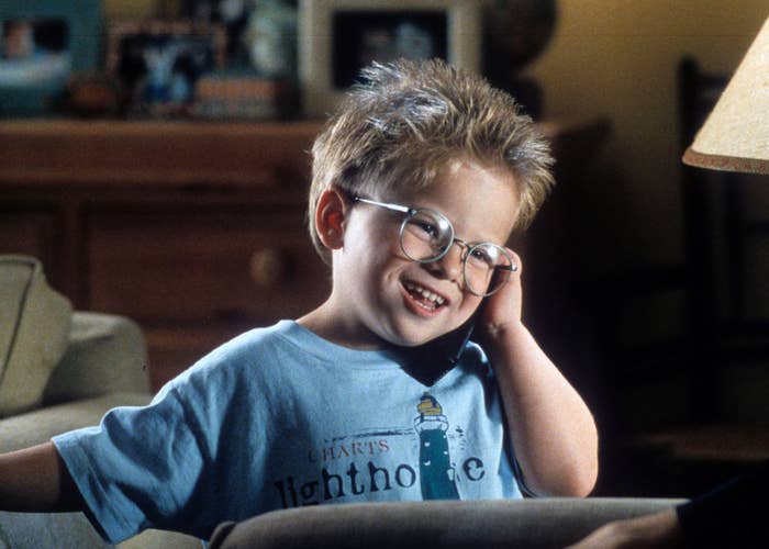 closeup of a kid wearing eyeglasses on the phone