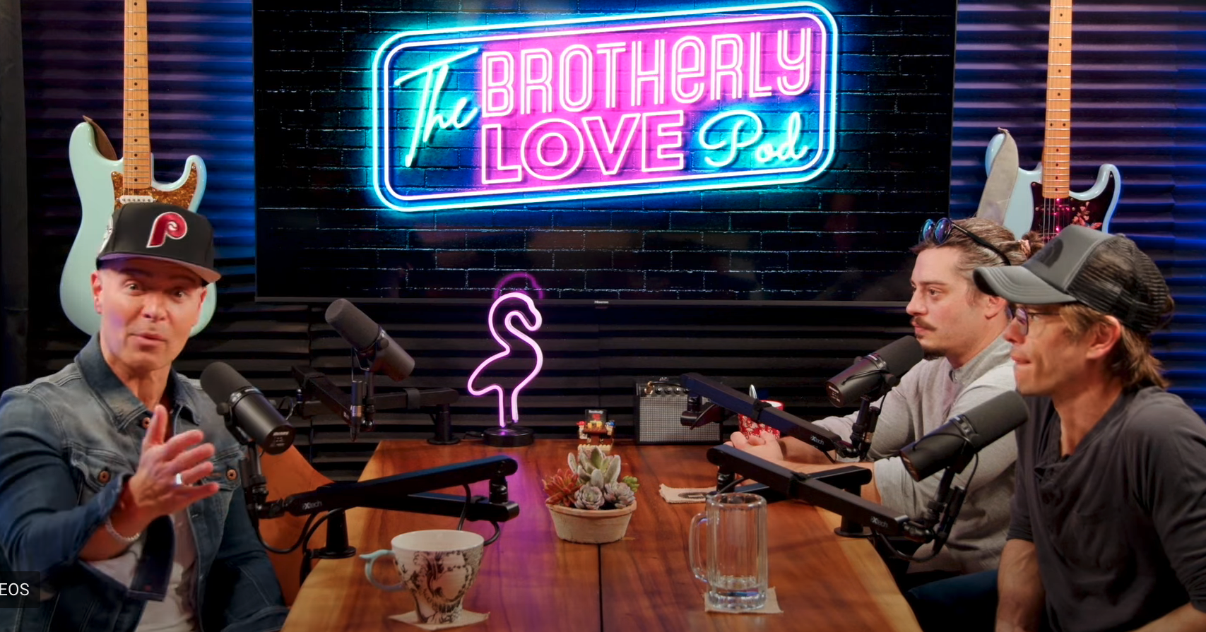 the brothers sitting around a table talking into the podcast mics