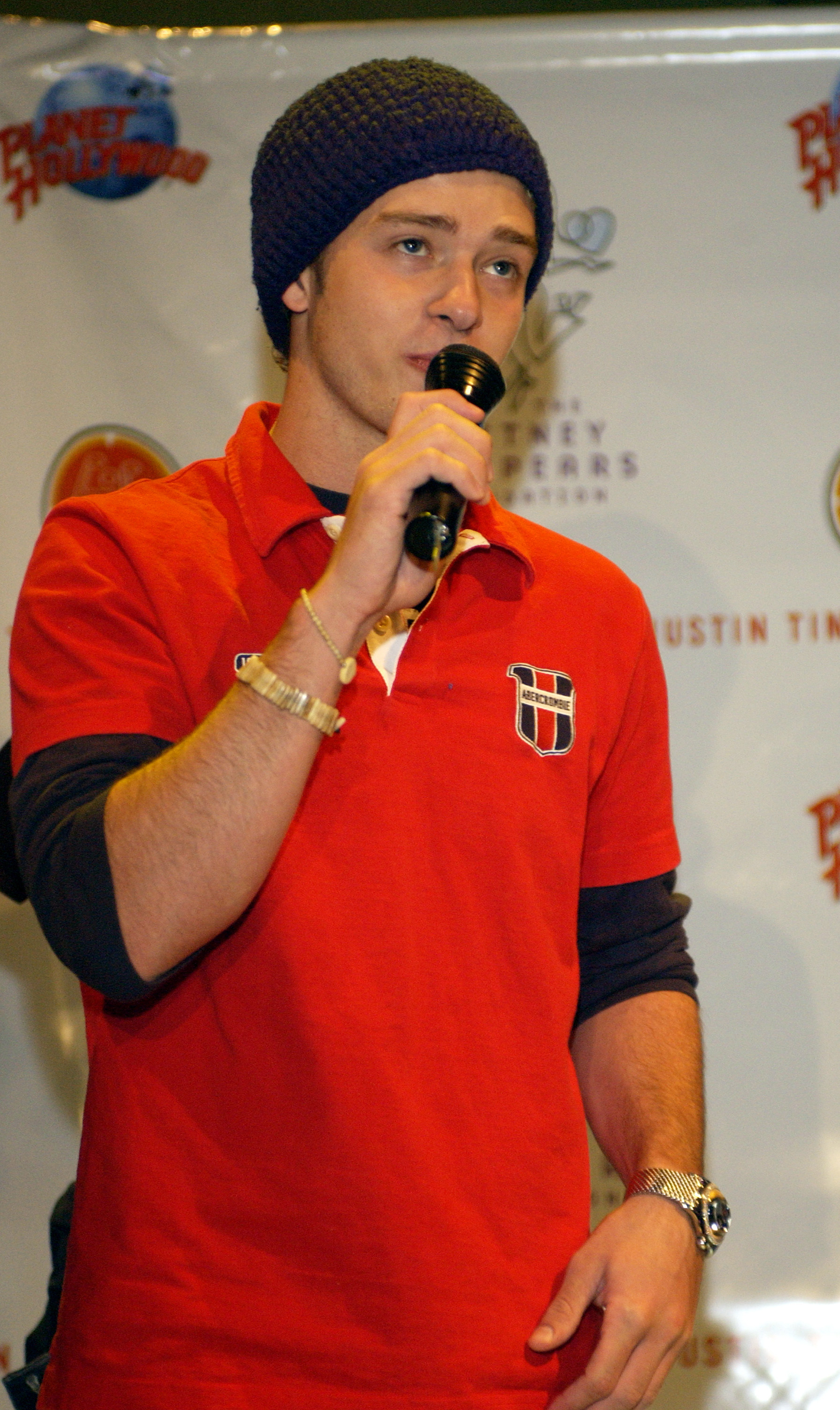 justin wearing a beanie and polo speaking into a mic