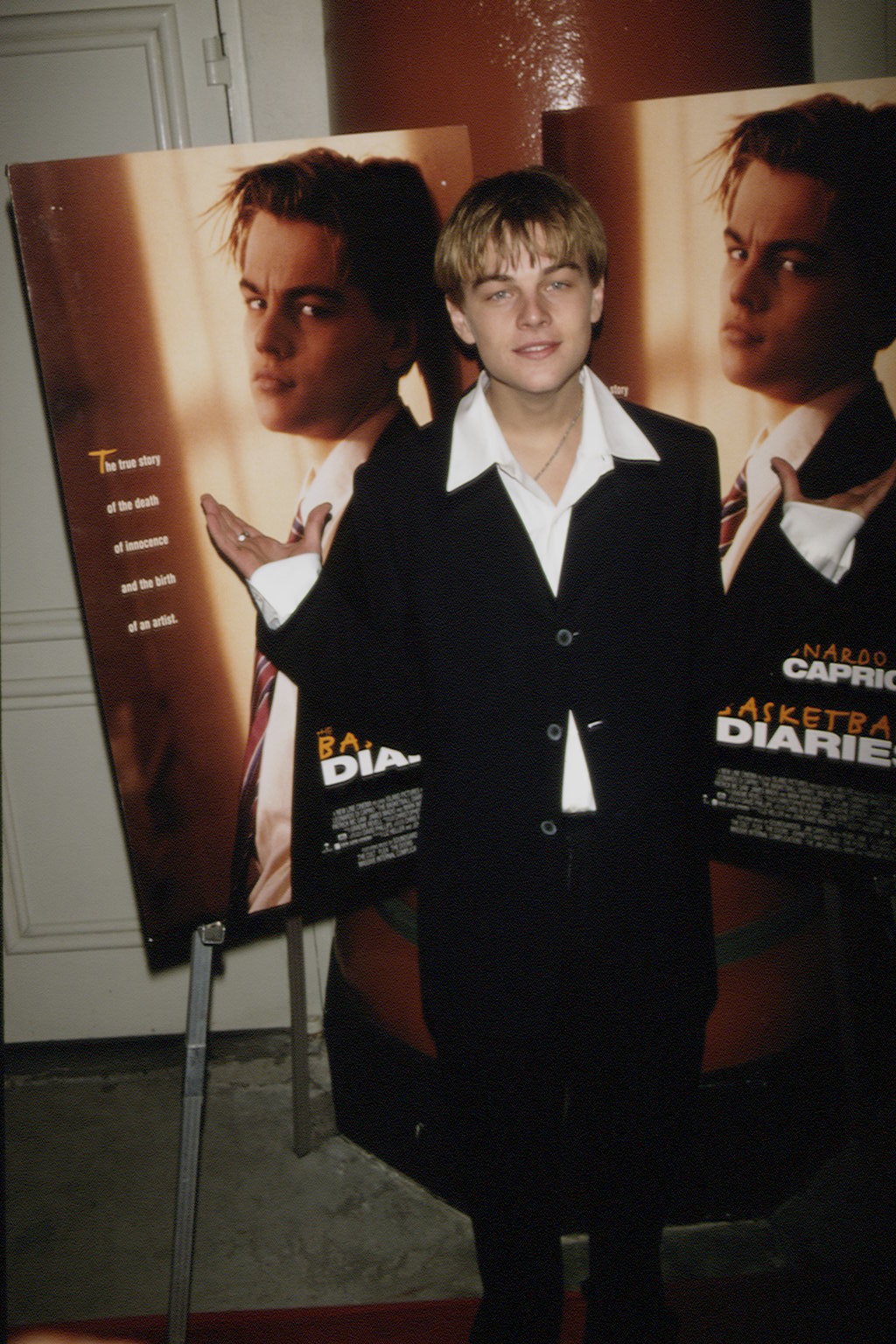 a young leo standing in front of the movie poster