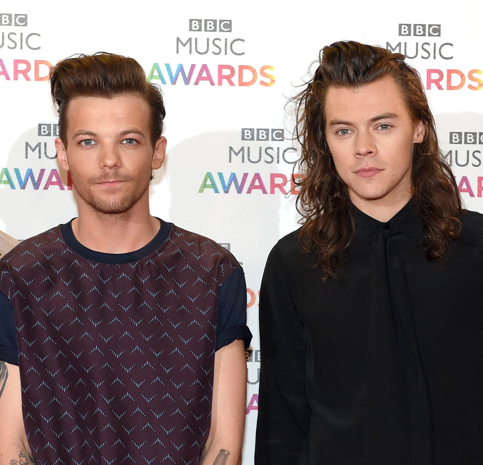closeup of louis and harry standing next to each other at an event