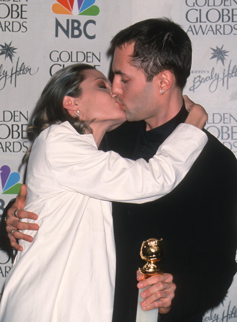 the two kissing as he holds her award