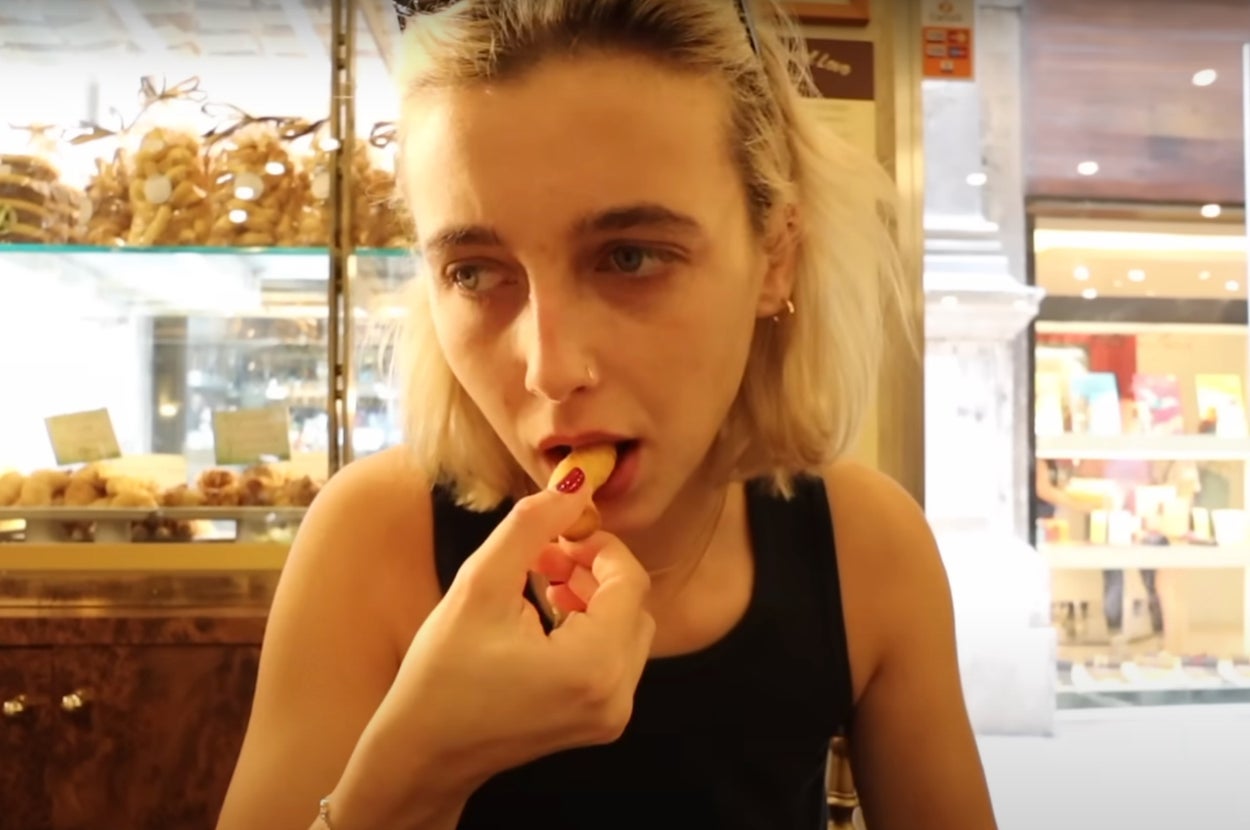 Emma Chamberlain eating a cookie in Italy