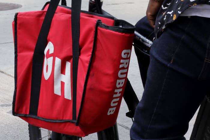 A delivery worker carries a Grubhub bag