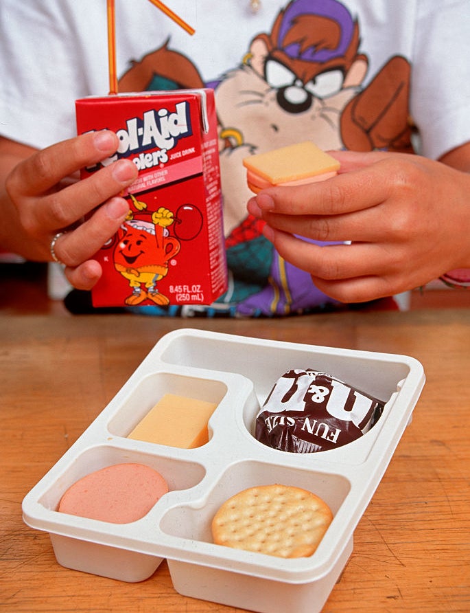 someone eating lunchables with a kool-aid juice box