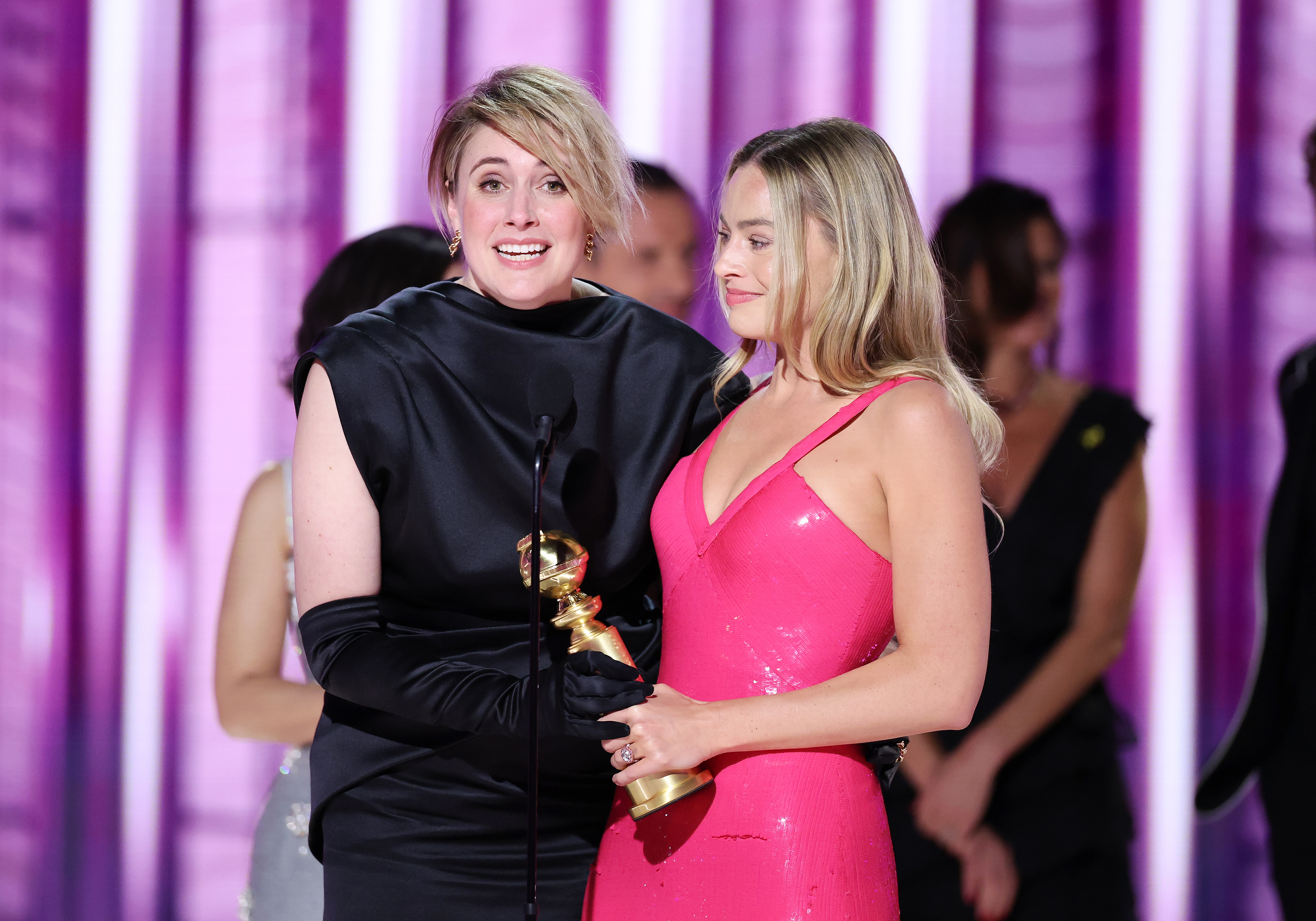 Greta and Margot holding an award onstage