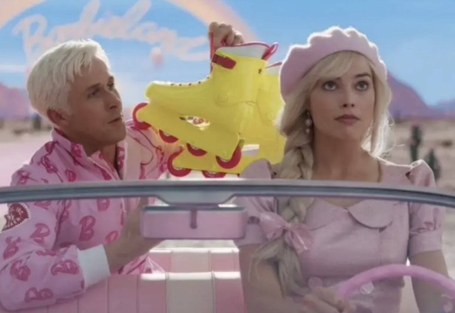 Ryan Gosling as Ken holding skates and Margot as Barbie driving a car