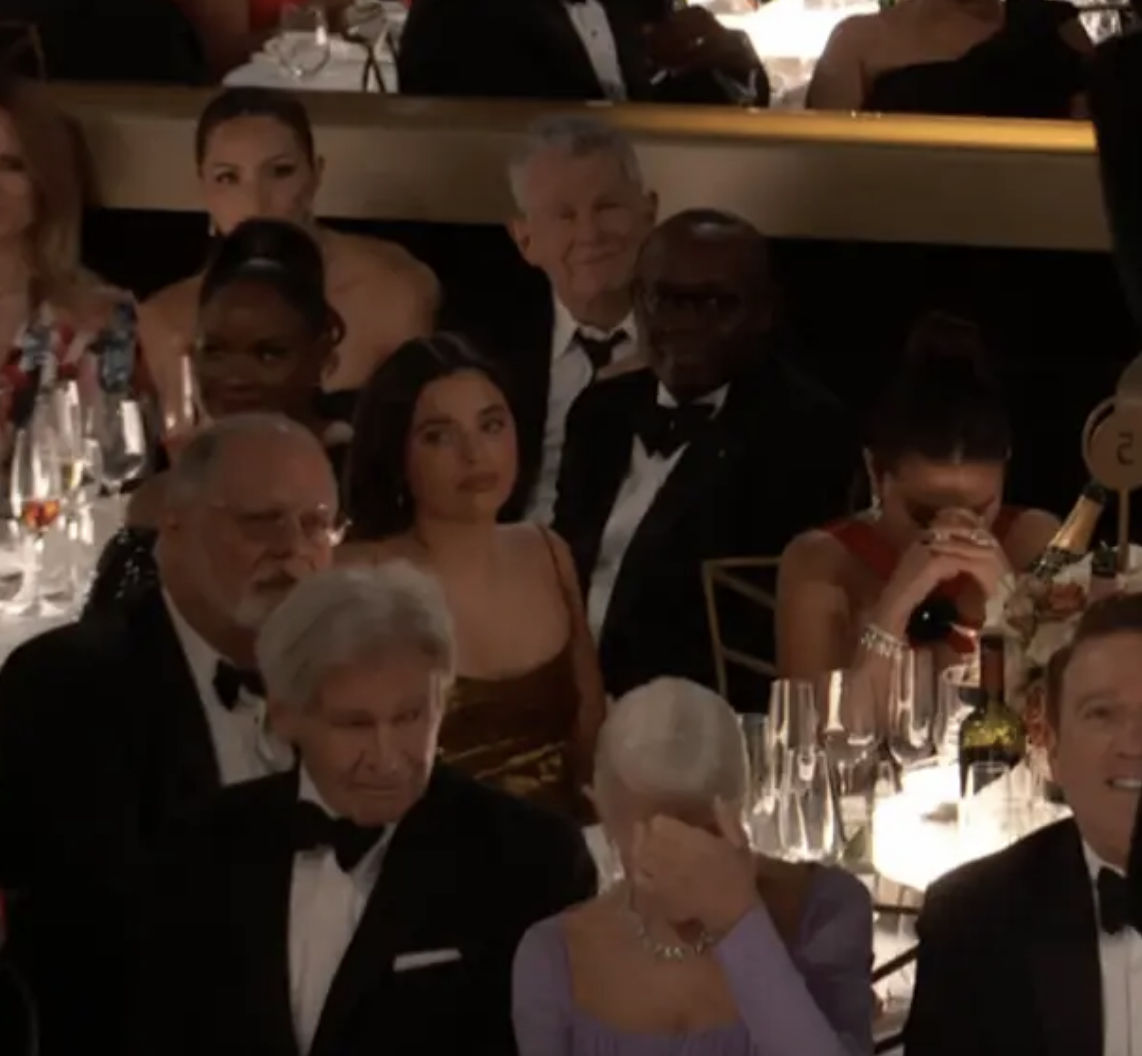 Helen seated next to Harrison Ford and covering her face in the crowd