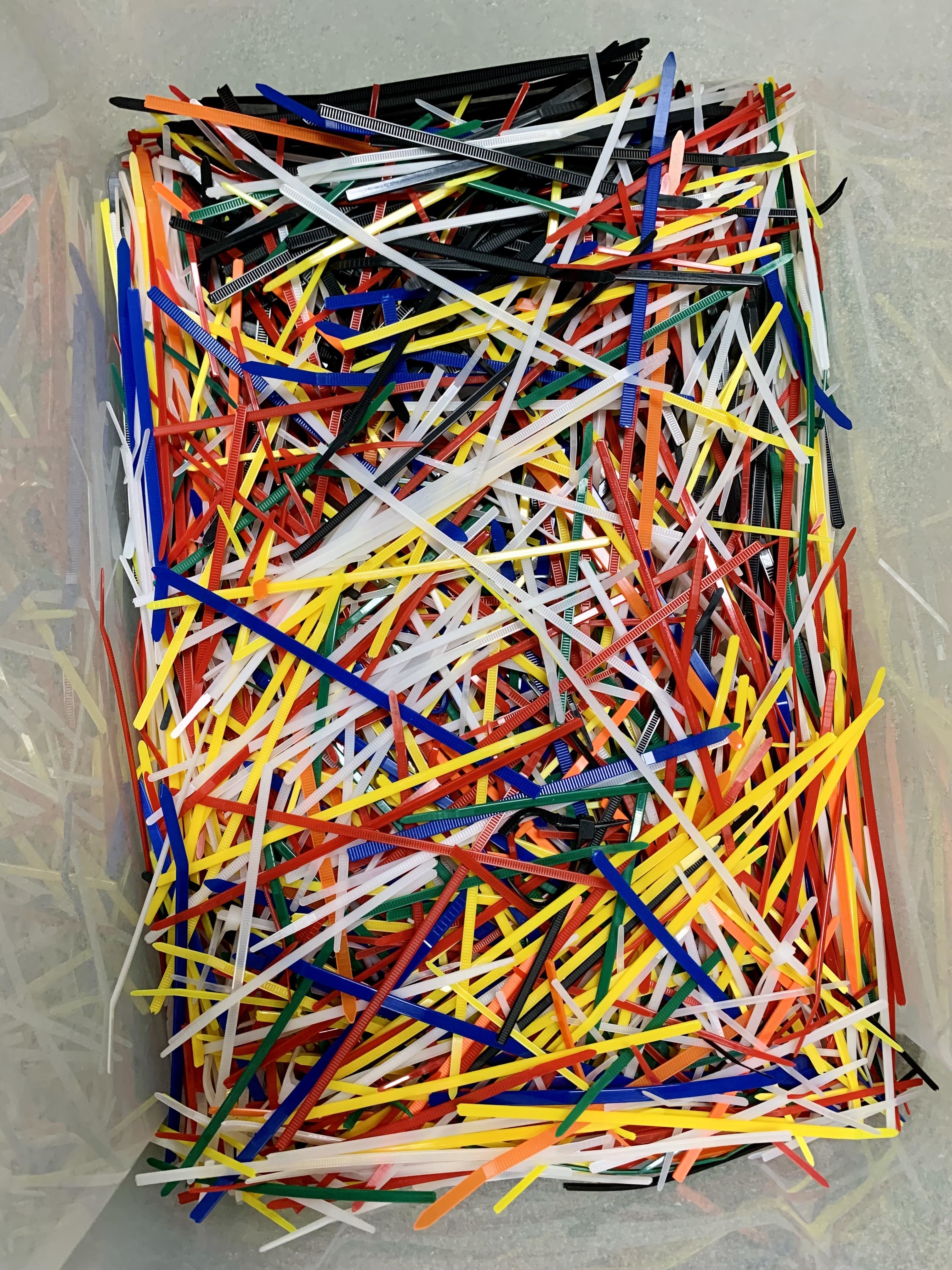 A plastic bin full of colorful plastic zip ties