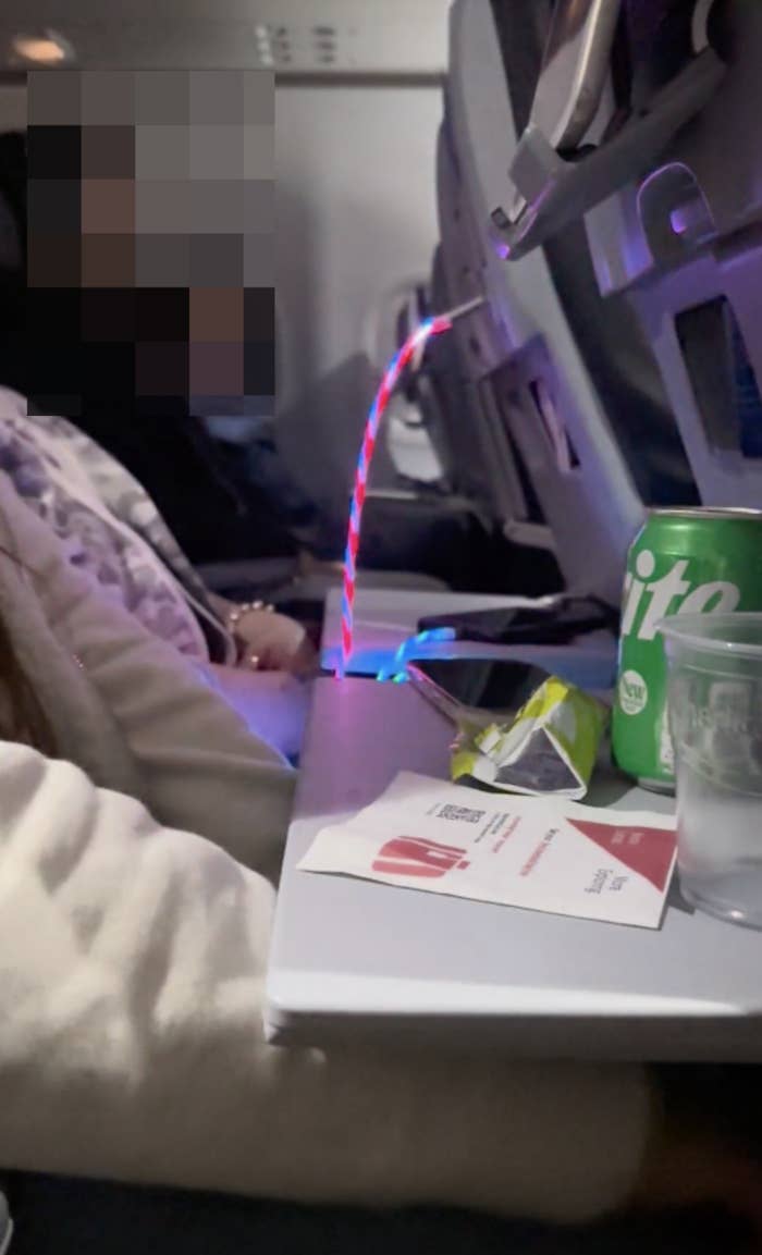 A person&#x27;s charger cord on a plane