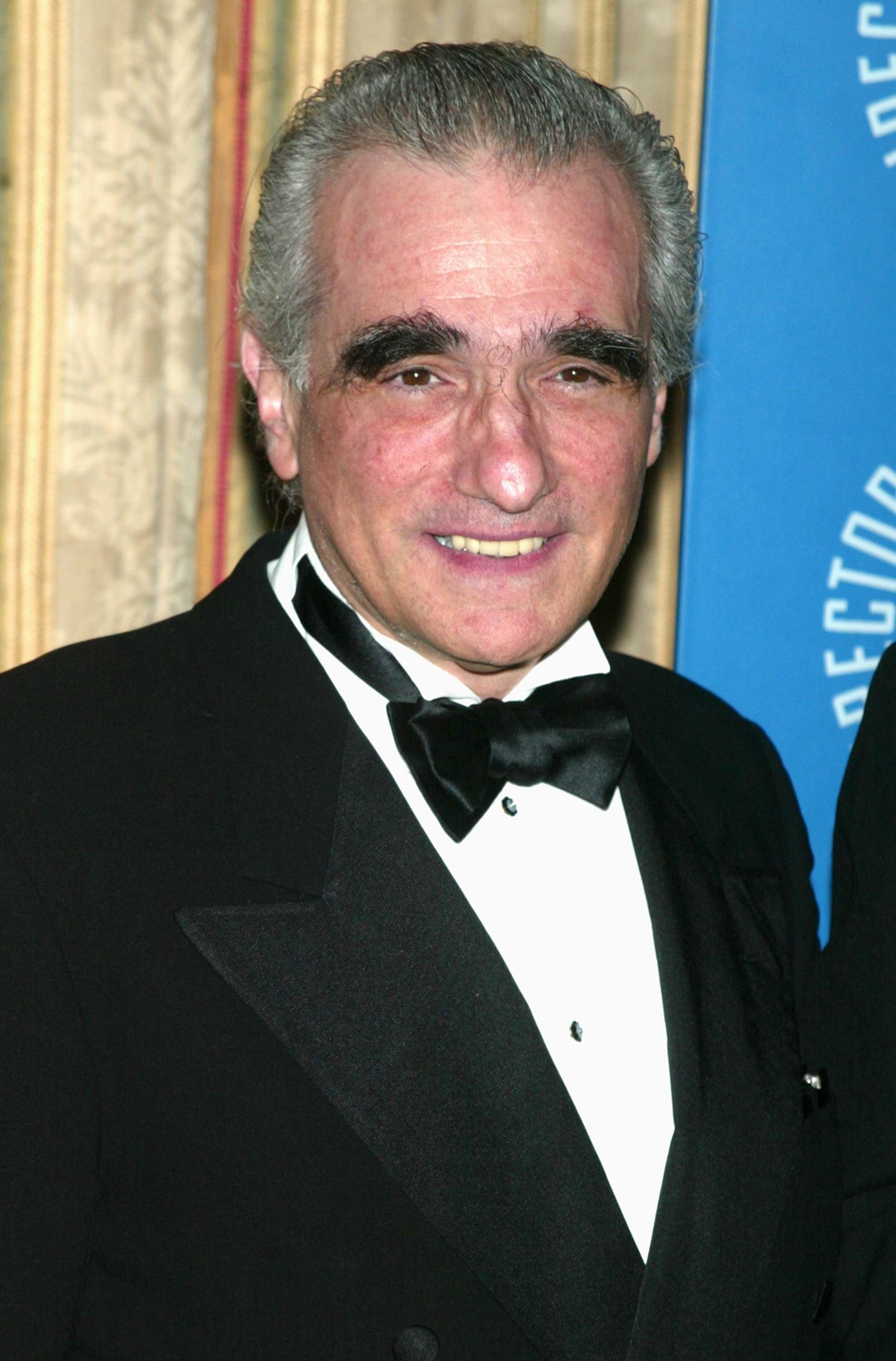 Close-up of Martin smiling in a suit and bow tie at a media event