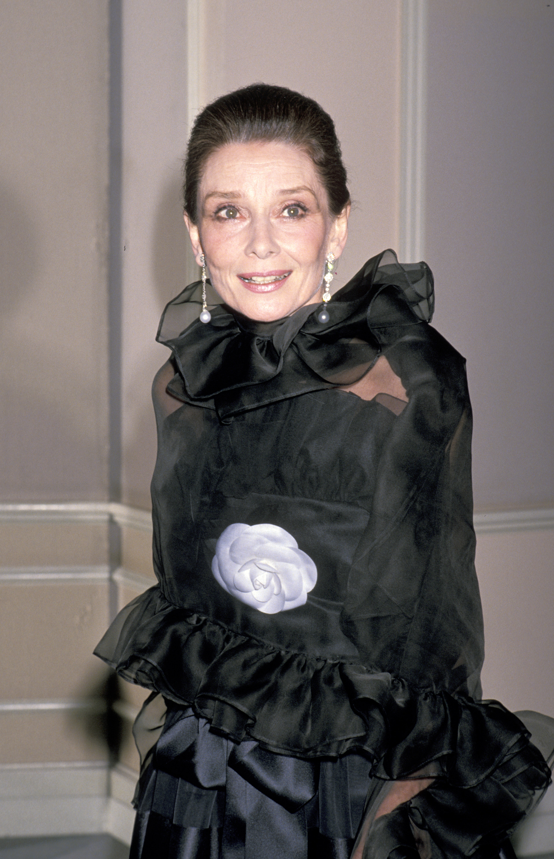 Close-up of Audrey smiling and wearing a floral-accented, frilly outfit