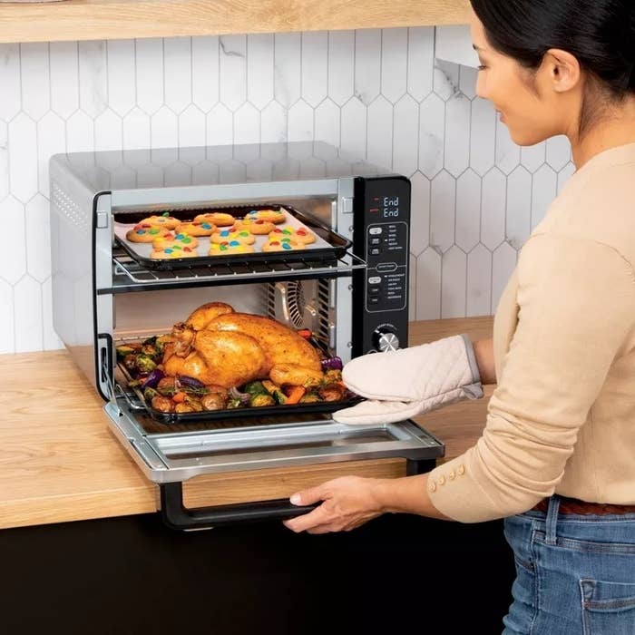 model using the oven to cook chicken on the bottom and cookies on the top