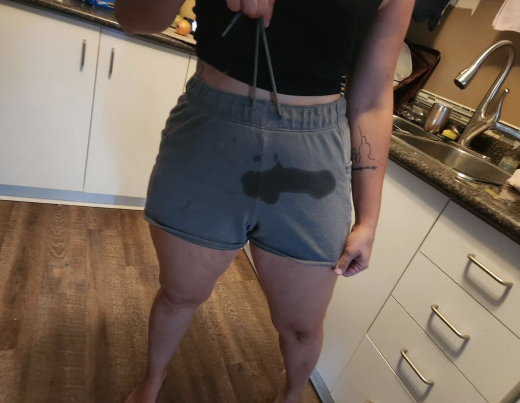 a woman who has a stain on her shorts